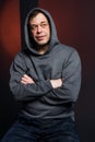 Studio portrait of a 40-50-year-old laughing man in a gray hoodie on a neutral background with a hood on his head, looking away. Royalty Free Stock Photo