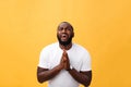 Studio portrait of young African American man in white shirt, holding hands in prayer, looking at the camera with Royalty Free Stock Photo