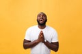 Studio portrait of young African American man in white shirt, holding hands in prayer, looking at the camera with Royalty Free Stock Photo