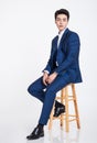 Studio portrait of a young Asian business man sitting in a chair