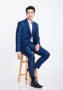 Studio portrait of a young Asian business man sitting in a chair