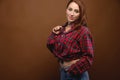 studio Portrait of a young attractive Caucasian woman in a red shirt and glasses on a brown background. Advertising Royalty Free Stock Photo