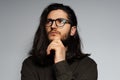 Studio portrait of young attractive thoughtful man with long hair. Royalty Free Stock Photo