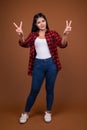 Studio portrait of young beautiful Asian woman making peace sign Royalty Free Stock Photo