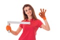 Studio portrait of young beautiful brunette girl in uniform makes renavation with tools in hands showing OK and smiling