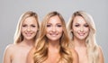 Studio portrait of young, beautiful and natural blond women over grey background. Close-up of smiling girls. Face Royalty Free Stock Photo