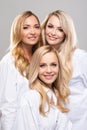 Studio portrait of young, beautiful and natural blond women over grey background. Close-up of smiling girls. Face Royalty Free Stock Photo