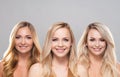 Studio portrait of young, beautiful and natural blond women over grey background. Close-up of smiling girls. Face Royalty Free Stock Photo