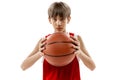 Studio portrait of young boy, basketball player in red uniform posing isolated over white background Royalty Free Stock Photo