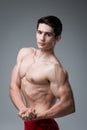 Studio portrait of a young brunette caucasian man on gray background posing. Puberty theme, problem skin, teen acne