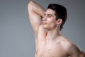 Studio portrait of a young brunette caucasian man on gray background posing. Puberty theme, problem skin, teen acne