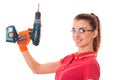 Studio portrait of young cheerful brunette girl in uniform and glasses makes renavation with drill in hands smiling on