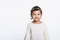 Studio portrait of a young girl wearing a flower crown and looking at the camera and smiling with a happy smile