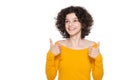 Studio portrait of a young girl on white background giving thumbs up while smiling and looking up. Ok sign. Royalty Free Stock Photo