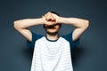 Studio portrait of young guy holding arms on face. Sad man on blue background Royalty Free Stock Photo