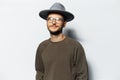 Studio portrait of young handsome guy, wearing grey hat eyeglasses. Royalty Free Stock Photo