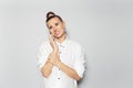 Studio portrait of young happy disappoint girl with hair bun talking on smartphone, on grey background, looking up, wearing white