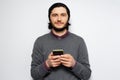 Studio portrait of young man with smartphone in hands on white background Royalty Free Stock Photo