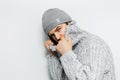 Studio portrait of young man wearing hat and sweater on white background. Royalty Free Stock Photo