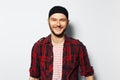 Studio portrait of young smiling attractive man, wearing red plaid shirt and black headband Royalty Free Stock Photo