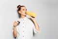 Studio portrait of young smiling girl drinking water from steel thermo bottle of yellow color on white background Royalty Free Stock Photo