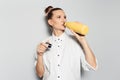 Studio portrait of young smiling girl, drinking water from the thermo bottle of yellow color on white background. Royalty Free Stock Photo