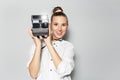 Studio portrait of young smiling girl, photographer making photo with vintage camera. Royalty Free Stock Photo