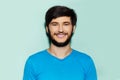 Studio portrait of young smiling guy in blue shirt on background of aqua menthe color. Royalty Free Stock Photo