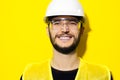 Studio portrait of young smiling man architect, builder engineer, wearing construction safety goggles, hard helmet. Royalty Free Stock Photo