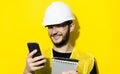 Studio portrait of young smiling man architect, builder engineer, wearing white construction safety helmet, glasses and jacket.