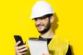 Studio portrait of young smiling man architect, builder engineer, wearing white construction safety helmet, glasses and jacket. Us Royalty Free Stock Photo