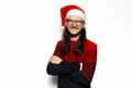 Studio portrait of young smiling man in red sweater, with crossed arms, wearing Santa Claus hat and eyeglasses. Royalty Free Stock Photo