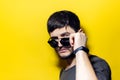 Studio portrait of young smiling man wearing black on yellow background. Royalty Free Stock Photo