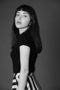 Studio portrait of a young woman against plain black background