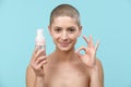 Studio portrait of a young woman holding a bottle of gentle foam facial cleanser. Beauty products and skin care concept. Royalty Free Stock Photo