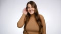 Studio portrait of young woman holding hand near ear and listening. Concept of gossips, getting information and