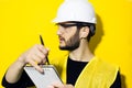 Studio profile portrait of young modern man architect, builder engineer, sketching in his notebook, wearing construction safety he Royalty Free Stock Photo