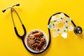 Studio shoot Chinese herb medicine and pills wrapped with a stethoscope on yellow Royalty Free Stock Photo