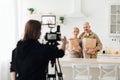 Studio shoot and family at home with grocery shopping. Photographer with camera makes photo