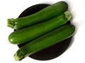 Studio shot of three zucchinis on black plate - isolated on white Royalty Free Stock Photo