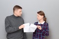 Studio shot of adult couple holding and tearing paper sheet Royalty Free Stock Photo