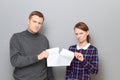 Studio shot of adult couple holding and tearing paper sheet Royalty Free Stock Photo