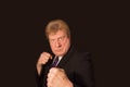 Studio shot of angry senior businessman with fist raise against dark background Royalty Free Stock Photo