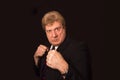 Studio shot of angry senior businessman with fist raise against dark background Royalty Free Stock Photo