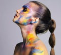 Having a major moment with her makeup. Studio shot of an attractive young woman with brightly colored makeup against a