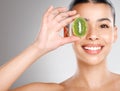 There's no beauty like natural beauty. Studio shot of an attractive young woman holding kiwi fruit to her face Royalty Free Stock Photo