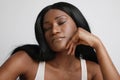 Studio shot of beautiful black woman, with closed eyes, posing over white wall.Skin care concept. Royalty Free Stock Photo