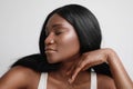 Studio shot of beautiful black woman, with closed eyes, posing over white wall.Skin care concept. Royalty Free Stock Photo