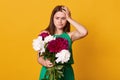 Studio shot of beautiful brunette girl holds big bouquet of burgundy peonies in hand, thoughtful woman with flowers keeps hand on