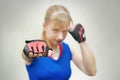 A studio shot of beautiful fitness woman training boxing or functional exercise. The girl shows the fist. Training melee. Women`s